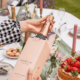 Person at an outdoor picnic unboxing a bottle of Roebuck Rose De Noirs.