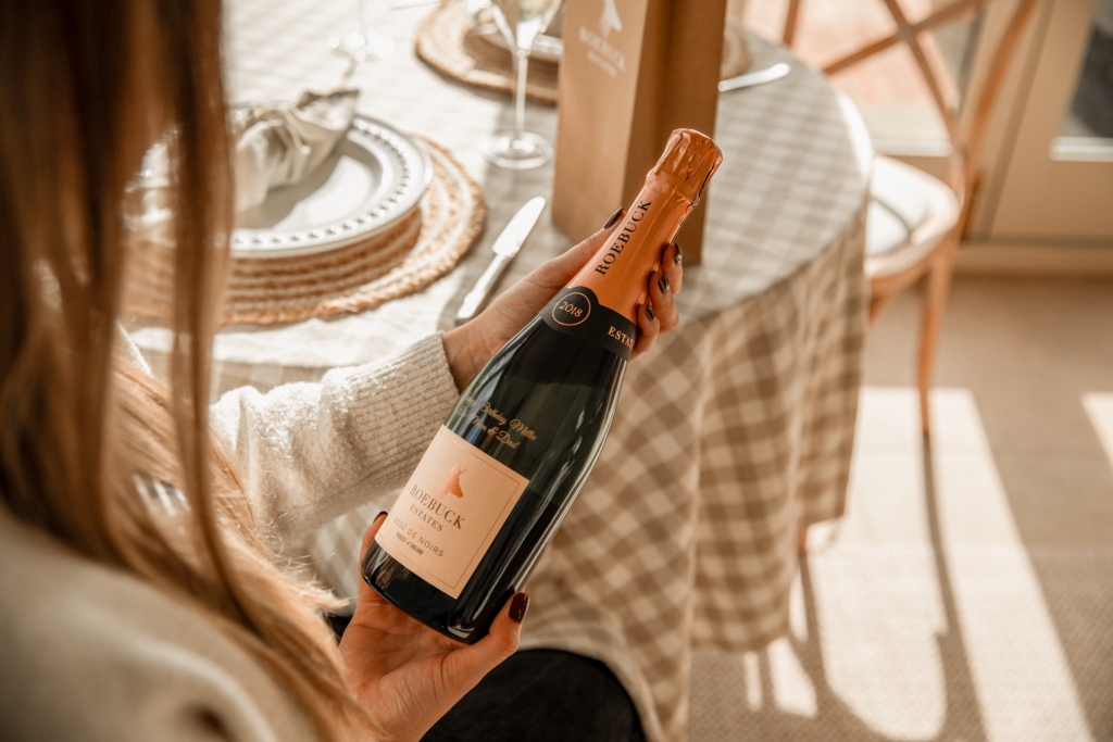 Woman holding a personalised bottle of Roebuck Rose De Noirs.